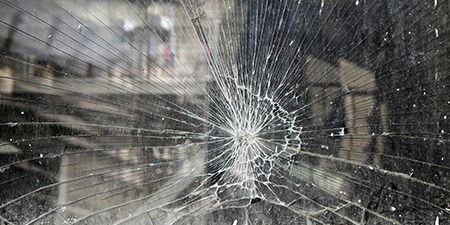 Primer plano de una ventana con cristales rotos.
