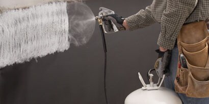Person spraying adhesive with applicator
