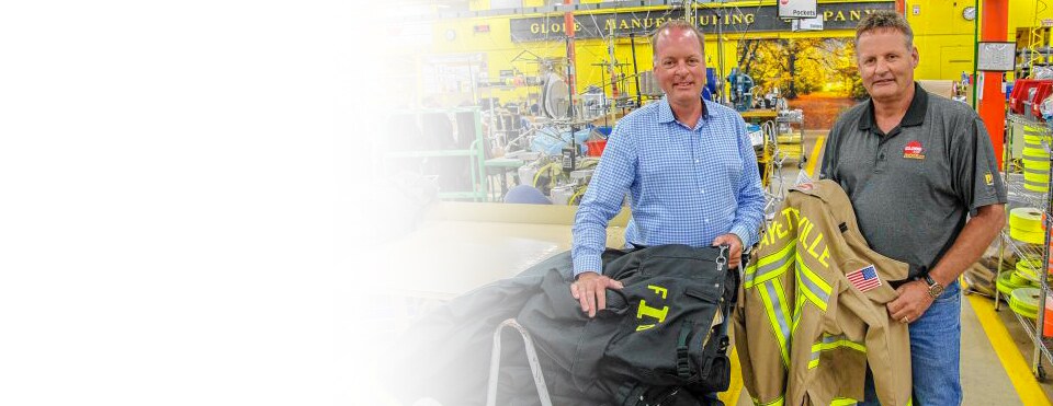 Employees of Globe Manufacturing Company, holding firefighter jackets, equipped with 3M Scotchlite Reflective Material