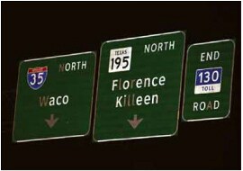In a low-angle photo of three highway signs, some letters are less bright, making the signs difficult to read.
