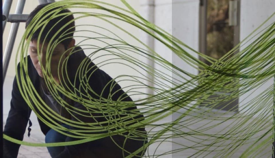 Karine Fellini, french-born artist shown creating artwork with Scotch Performance Masking tape on a window.