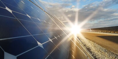Paneles solares produciendo energía solar con el sol en el fondo
