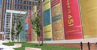 Looking up from the sidewalk, a view of the Kansas City Central Library parking lot. Wrapped in 3M Controltac Graphic Film, this parking lot appears to be a line of giant books.
