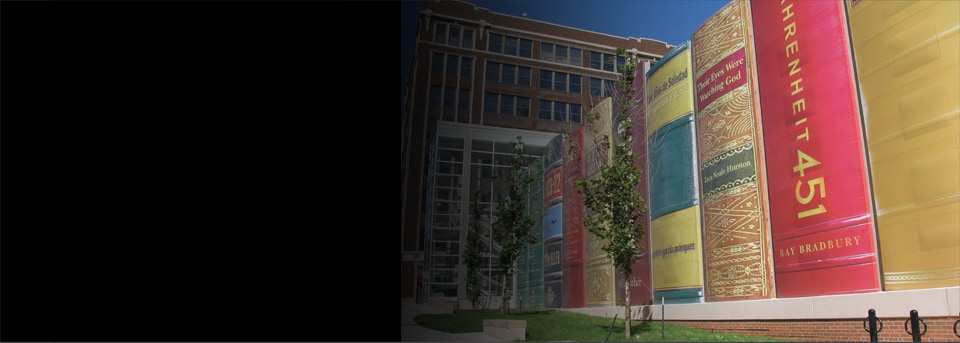Looking up from the sidewalk, a view of the Kansas City Central Library parking lot. Wrapped in 3M Controltac Graphic Film, this parking lot appears to be a line of giant books.