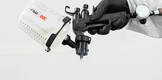 Técnico de pintura pulverizando vehículo.
