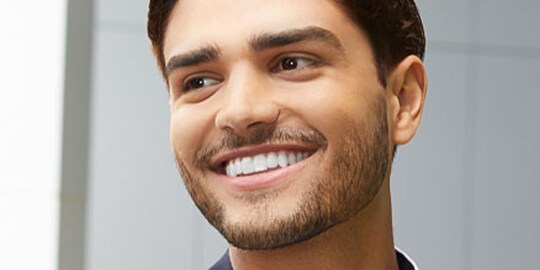 Man smiling wearing aligners
