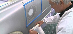 Persona reparando la puntura del vehiculo