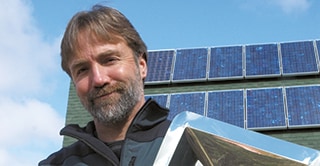 3M scientist Tim Hebrink posing with films that he has been testing films for their ability to increase the energy output of solar panels.