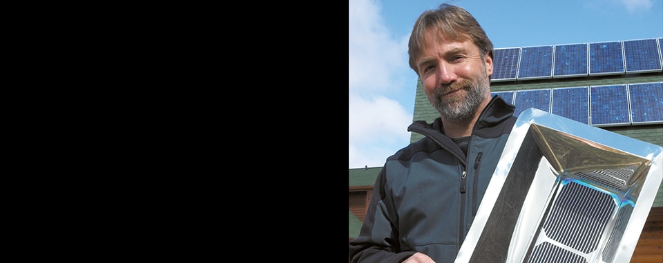 3M scientist Tim Hebrink posing with films that he has been testing films for their ability to increase the energy output of solar panels.