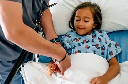 Nurse adheres medical tape to young patient