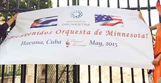 A banner that displays the Cuban and U.S. flags and the text: Bienvenidos Orquesta de Minnesota! Havana, Cuba, May 2015