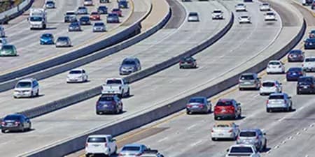 Docenas de coches circulan por varias autopistas vecinas, demostrando la necesidad de señalizaciones viales duraderas.
