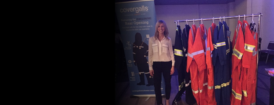 Alicia Woods, founder of Covergalls, standing near a rack of her product