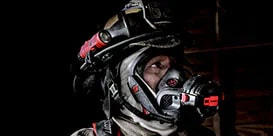 Bombero usando un equipo de respiración autónomo en un entorno oscuro.
