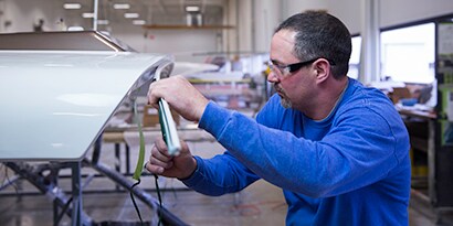 Technician in an assembly line plant creates an adhesive bond
