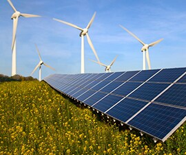 Solar panels and wind turbines producing energy in a field.