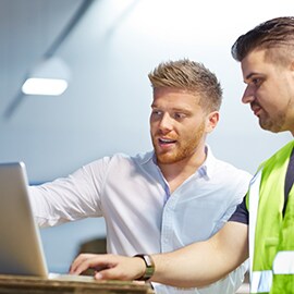 Two experts use the roadway asset management system to plan their team's work.