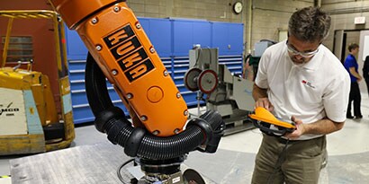 3M application engineer programming a robot
