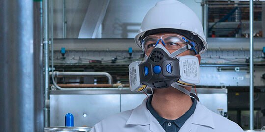 Respirador de 3M protege a un hombre en una fábrica industrial
