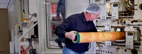 Image of a press operator inserting a cylinder into the press
