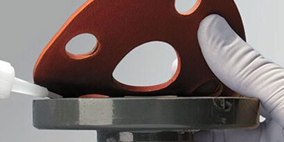 Liquid adhesive being applied to a gasket
