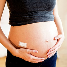 Medical adhesive on a pregnant woman’s stomach