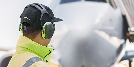 back view of worker wearing a bump cap and hearing protection
