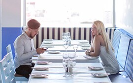 couple sitting at a restaurant table with no other patrons around them.