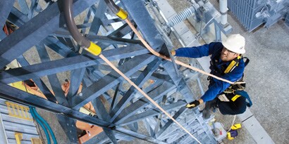 Worker climbing oudoor rig in 3M Fall Protection gear
